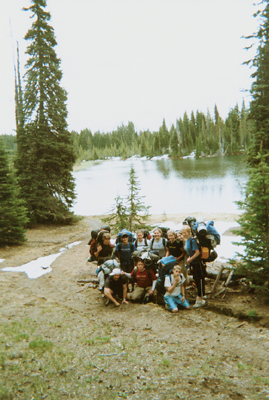Youth wearing packs posing by lake