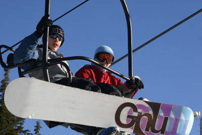 Derek & Suz with snowboards on lift
