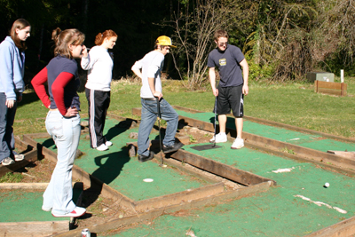 youth playing miniature golf in the sunshine