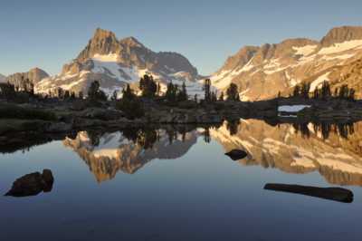 First sunrise on Banner Peak over a tarn near camp