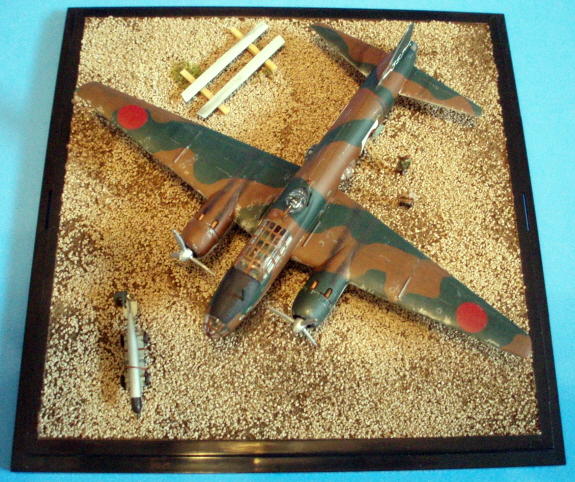 Overhead view of the finished diorama, showing the overall layout. You get a sense of impending action (at least I like to think so) from the guys working under and around the aircraft, the torpedo at the ready, some of the crew already in the cockpit and one having a last word with an officer type before boarding. The hinomaru's on top of the wings are incorrect - they should have a thin white outline, but I had no way to cut a perfect circle in white decal paper with the tools I have, and several attempts to create painting masks in the correct diameter prompted me to give up on complete accuracy.