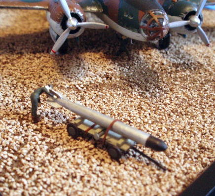 The scratchbuilt Type 91 Mod 2 aerial torpedo, on its scratchbuilt trolley. Dimensions for both were gleaned from several sources. The ground crewman is examining the little bronze props at the back of this potent engine of destruction. I fudged a little on the fins - there are supposed to be eight, in three different styles. After gluing four on, I decided that discretion was the better part of historical accuracy.