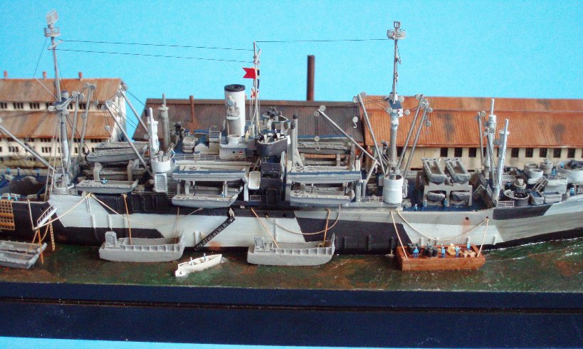 Center section of the ship, showing the Landing Craft Medium, normally stowed over the No. 4 hatch, here moored next to the ship so the LVTs can be swung aboard.