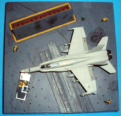 This overhead view shows how compact but busy the diorama is - you have the Hornet at center stage, but action is suggested by the deck tractor, the raised JBD and the deck crew making various gestures as the plane is towed into position.