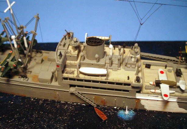 The superstructure was where a lot of the photoetch went, for the columns between decks, railings, lifeboat falls  and the funnel grille. There are some crewmen up there manning the 25-mm antiaircraft cannon, and a signalman doing his thing with a couple of flags. I added stretched sprue radio aerials to match what was on the Kamikawa Maru boxtop painting, with no clue as to how accurate that was. But it looks cool.