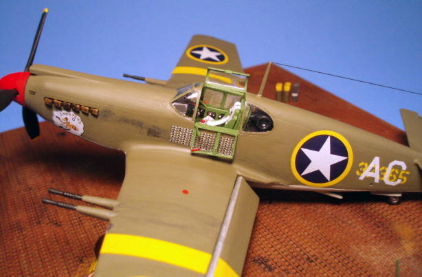 A view from the left wing to the cockpit, with the mission symbols underneath the opened left window. The antenna wire is stretched sprue, colored with a black permanent marker. Also evident are the dropped flaps with the half-round plastic stock added to give them the correct appearance.