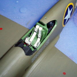Close-up shot of the Mustang's cockpit, showing the scratchbuilt seatbelts and harness, and ship's railing for the harness buckles.