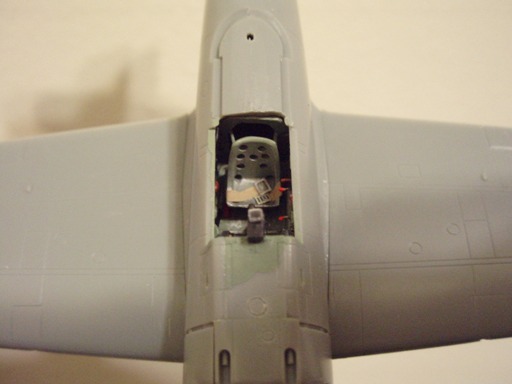 This overhead cockpit view shows the drilled-out holes in the pilot's seat and the cigarette paper seatbelts.