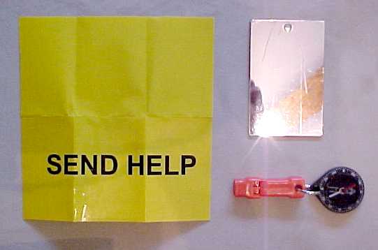 Large Personal Survival Kit, showing signaling devices that includes fluorescent yellow signal panel, mirror and whistle.