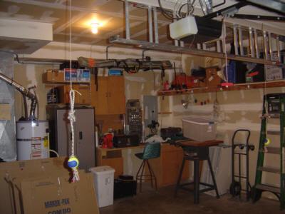 head wall, with rearranged work bench and cabinets and new shelving